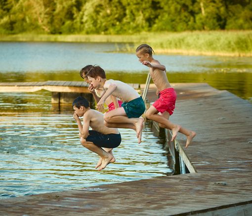Kids jumping into a lake